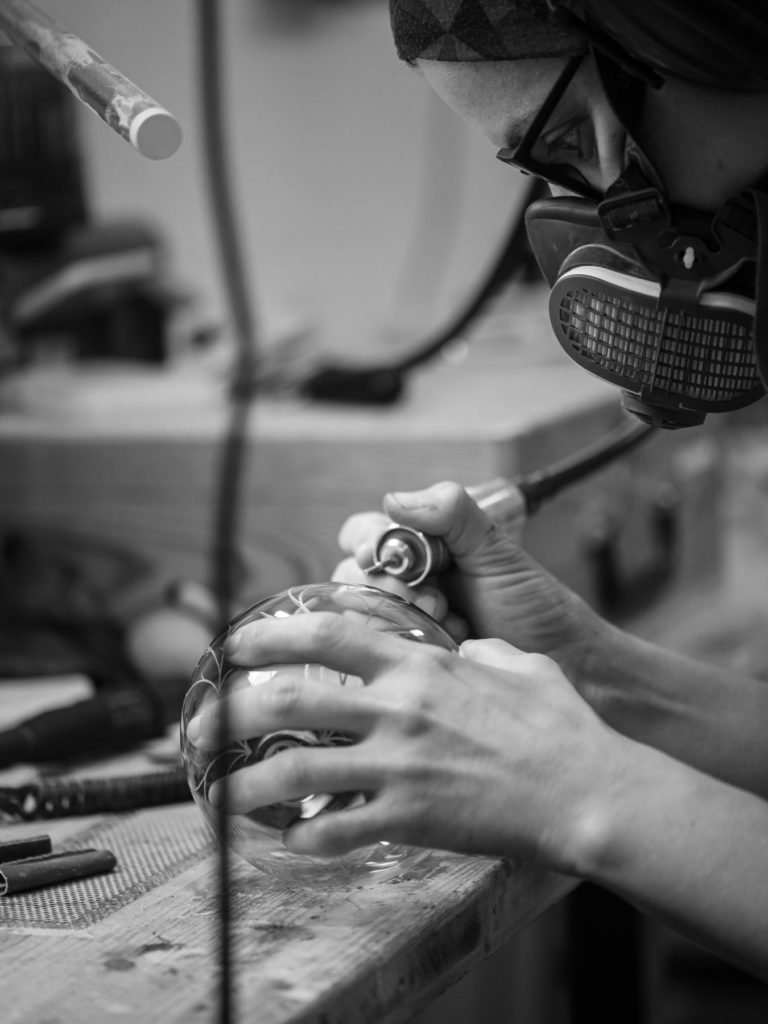 Coralie Saramago en train de graver du verre pendant l’évènement le Grand Atelier 2023